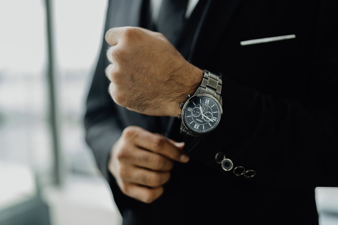 Close-up of a businessman adjusting his elegant wristwatch, showcasing luxury and style.